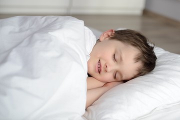 Fototapeta na wymiar Cute child is sleeping in white bed
