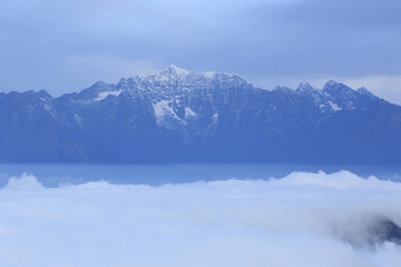 Fototapeta na wymiar beautiful rolling clouds and frozen mountain summits landscape