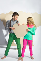 Love concept. Couple of kids. Boy and girl holding a cardboard heart