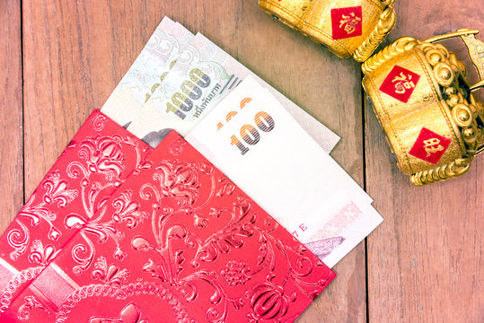 Close up Thai money in red envelope with golden object for chine