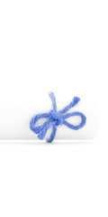 Handmade blue cord node tied on white message roll isolated