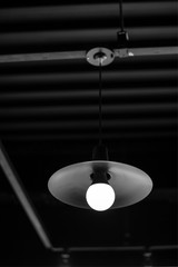 Light bulb turned on over black background. A black and white photo