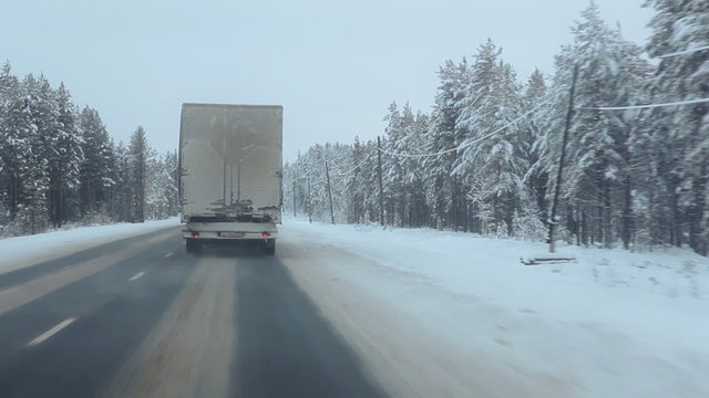 Drive next to cargo truck moving on winter road in north of Karelia, Russia
