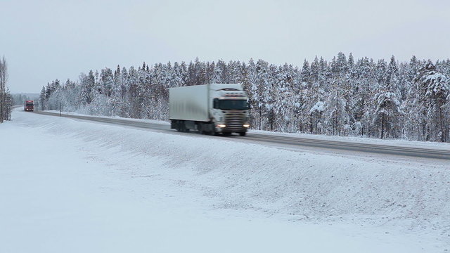 Freight truck drives on "Kola" route in Karelian woods at winter season. Federal road from St. Petersburg to Murmansk. Russia
