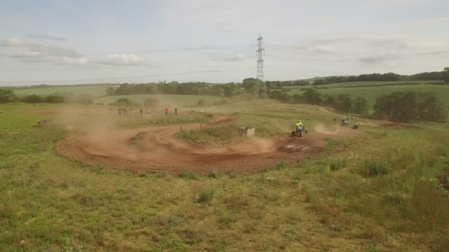 Tracking drone shot of quad bikes / off road vehicle on a dusty dirt track  
