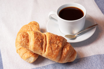 Breakfast with cup of black coffee and  croissants
