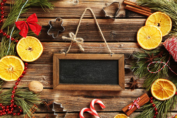 Christmas tree branch with dried oranges, cinnamon and anise star on wooden table