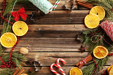 Christmas tree branch with dried oranges, cinnamon and anise star on wooden table