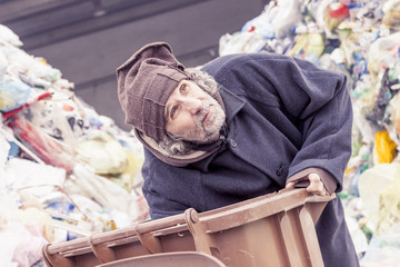 Fototapeta na wymiar homeless rummages in the dustbin of landfill