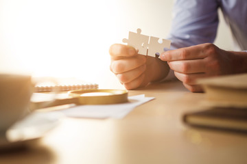 Building a business success. The hands with puzzles