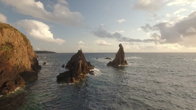 Stunning aerial shot on the Isle of Harris, Scotland, flying along the coastline at Uig with sea stacks

