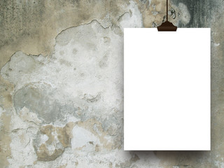 Close-up of one hanged paper sheet with clip on weathered wall background