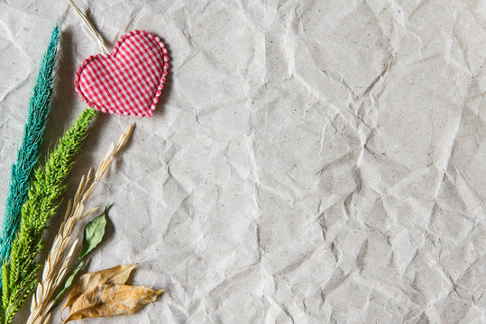 Beige crumpled paper with heart and withered flower for valentin