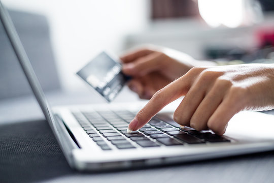 Woman holding credit card on laptop for online shopping