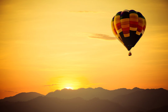 hot air balloon flight over mountain with sunset.