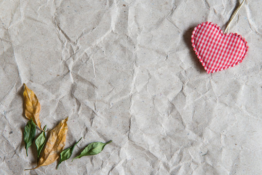 Beige crumpled paper with heart and withered leaves for valentin