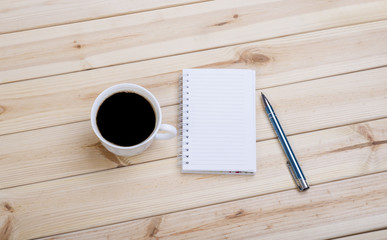 Checkered Spiral Notepad, Cup Of Coffee And Pen On Wooden Desk.