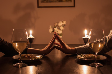 Loving couple holding hands during romantic dinner