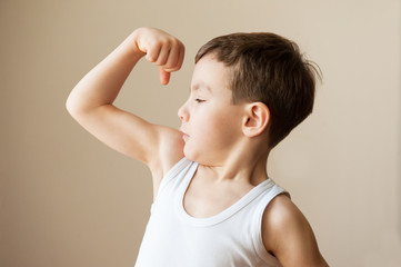 kid boy child showing muscles  fist strength training