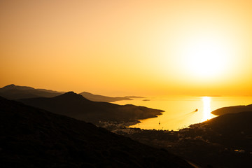 Landscape view of dramatic ocean coastline and port at sunset