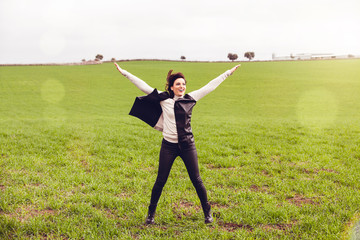 Fototapeta na wymiar Brunette woman jumping in the countryside. Happiness concept.