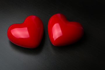 Fototapeta premium Two red hearts on dark background. St Valentine day concept