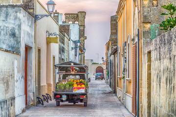 three-wheeled vehicle in street of fortified citadel