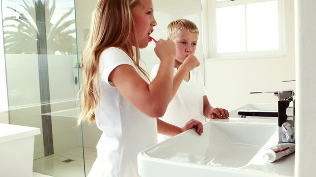 Siblings washing teeth together