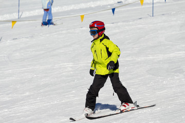 Fototapeta na wymiar Bambino principiante che scia sulla pista da neve