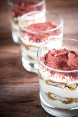 Tiramisu in the glasses on the wooden background