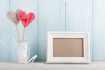 Valentine's Day heart shaped lollipop and white frame on blue wo