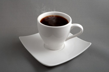 black coffee in a white cup on a grey background