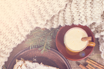 A cup of coffee, cinnamon, cake, knitted scarf - winter still life