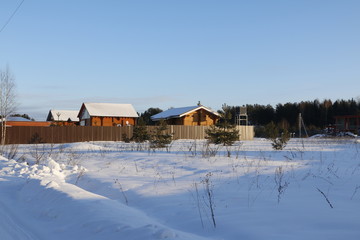Деревня в снегу в зимний солнечный день