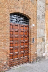 Old wooden door in Pisa, Italy