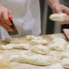 Chefs forming dough in order to prepare bread