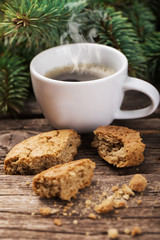 A cup of coffee with the branches of the Christmas tree on a wood