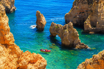 Tourist boat on turquoise sea water at Ponta da Piedade, Algarve region, Portugal