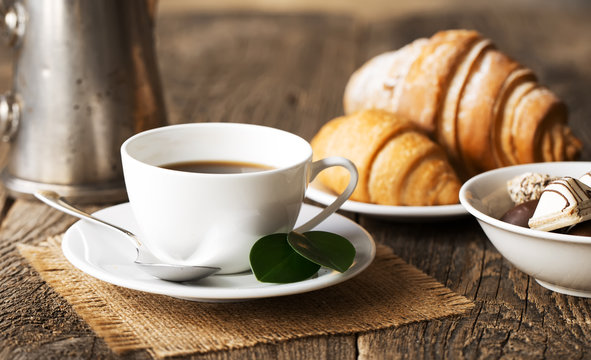 Hot coffee and pastries on a wooden background