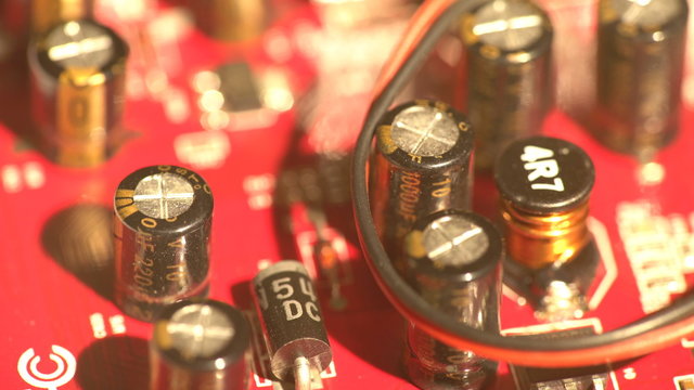 Top view of a red color computer electronics circuit board turning around