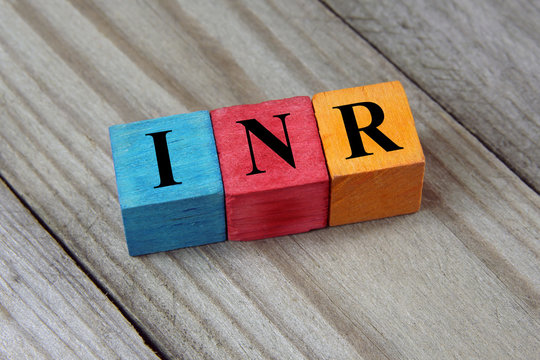 INR (Indian Rupee) sign on colorful wooden cubes