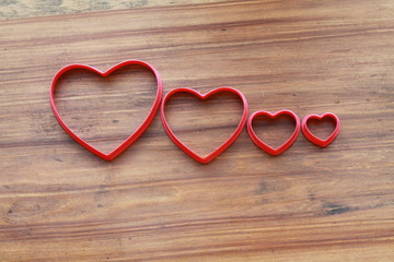 Empty red hollow hearts on a wooden background