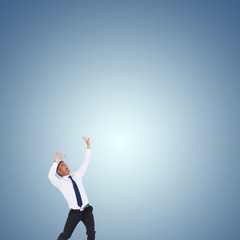 Composite image of businessman with hands raised 