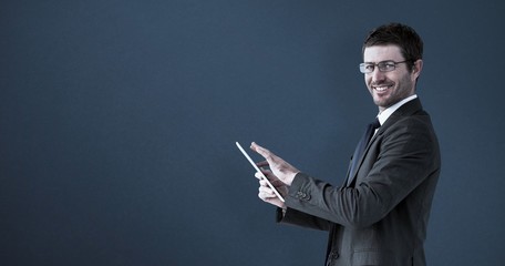 Composite image of businessman using his tablet pc 