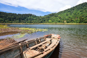 Fototapeta na wymiar Beautiful landscape of the Laguna Verde with a boat, in Apaneca, Ruta de Las Flores itinerary, El Salvador