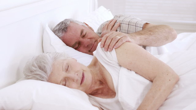 Senior couple sleeping in bed