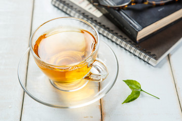 Tea and book on white wooden background