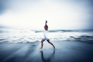 Young Woman with Arms Raised by the Beach Concept