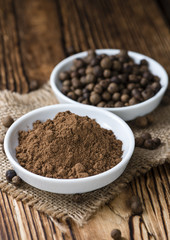 Old wooden table with Allspice powder