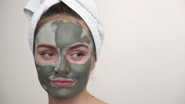 Woman with green clay mud mask on face 4K